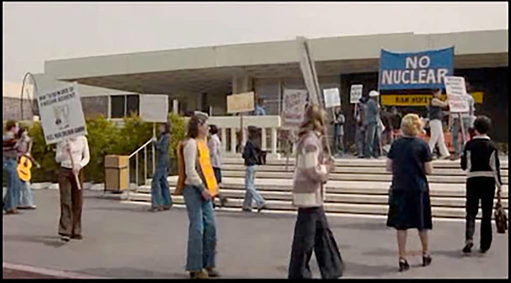 Students hold protest signs outside CalArts Main Building entrance.